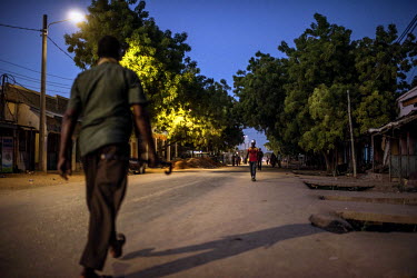 People walk along a street as evening falls. The town remains plagued by fear and suspicion in the wake of the 2015 terror attack on Garissa University.