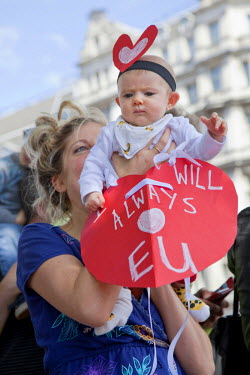 A woman holds up a placard and a baby during a rally in central London held by people protesting the result of the referendum to leave or remain in the European Union. A week earlier British voters de...