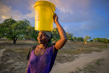 Elsa Amorinho, 30, a single mother living in the Mussanga community with her two sons and one daughter, collects water from the communal pump. Her life has been made easier with its installation. Howe...