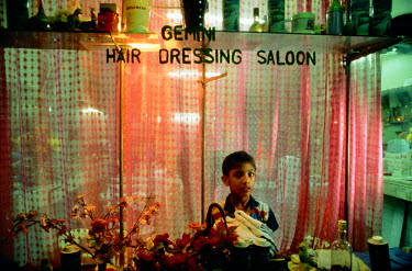 A boy in an ethnic Indian barber's shop in Georgetown.