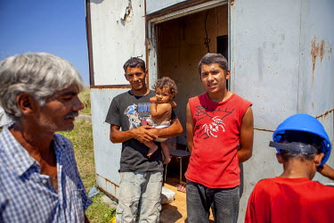 Rudolf (52, left) with his son Rudo who is holding his daughter. Beside Emil (20, red top), the men here are among six Roma families who have joined a pilot project called 'From Shack into a 3E (Ecolo...