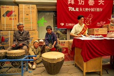 Ethnic Uighur musicians paid to attract passers-by to a Chinese electronic company's promotional campaign.