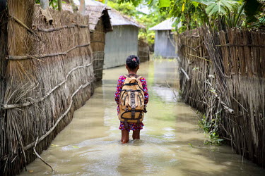 Akhi Akter wades through flood water to get to her class. Despite the floods she has exams coming up so must persevere.   At least 820,000 people have been affected by floods and the situation is dete...