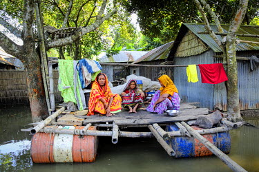 Omela and Safiya sitting on the pontoon they have built above the flood waters that enables them to keep an eye on their deluged homes.  At least 820,000 people have been affected by floods and the si...