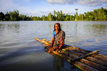 Nur Jahan sits on the banana palm stem raft that has been her refuge after she lost everything in flooding. She says she has lost her desire to live.   At least 820,000 people have been affected by fl...