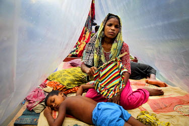 Furfura Begum, 35, and her daughter  Mukti Moni in the temporary shelter built on a train track where they are living after losing everything to flooding.  At least 820,000 people have been affected b...