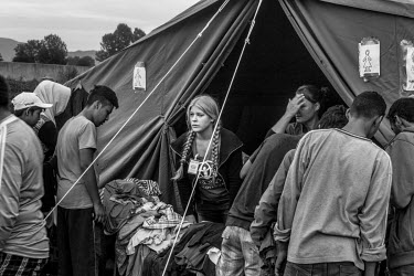 Refugees look through donated clothes being distributed by Solvenian NGO ADRA.