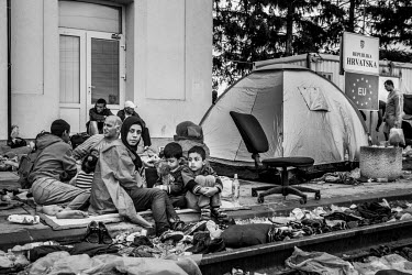 A group of refugees, trying to get on one of the scarce trains, camp out at the station.