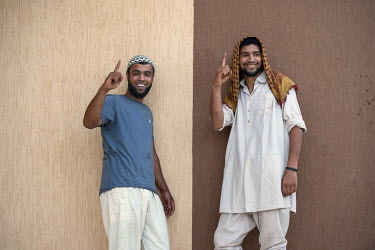 Hamsa Bin Nasser (right) and a comrade, both fighters with the Khaled Ibn-Al Waleed Brigade, make fun of a typical IS gesture. Two days after this picture was taken, during fighting with IS, Hamsa's a...