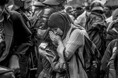 A refugee woman comforts her daughter crying during scenes of turmoil at the train station as thousands of refugees wait to get on a train or a bus.