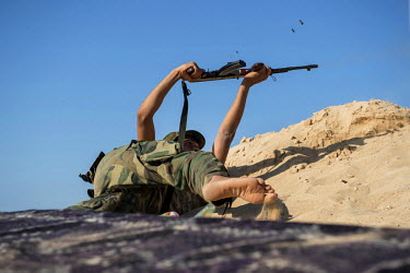 A fighter from the Al-Marsa Brigade, fighting IS in Sirte, exchanges fire with nearby snipers on a frontline position near the sea front.   Various Libyan army units, mainly made up of brigades ('Kati...