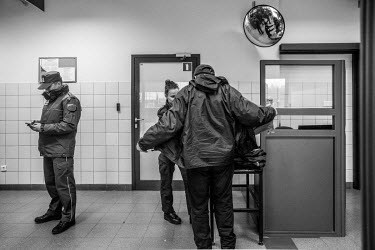A border guard checks beneath the coat of an Ukrainian man entering Poland.