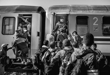 A group of refugees crowd on to one of the scarce trains which has arrived without any indication of its destination.