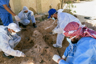 A forensic team digs up the body of an Islamic State fighter for reburial according to Islamic rites. The dead man and other fighters had been hastily buried there by fellow IS militants while heavy f...