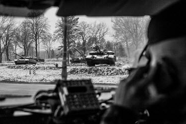 A vehicle from the Canadian Army drives past several tanks in the International Peacekeeping Training Center where Ukrainian troops are trained by Canadian and US Army.