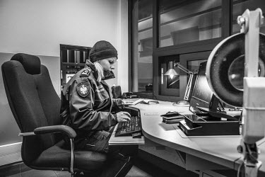 A border guard, working at the crossing between Poland and the Russian exclave of Kaliningrad, examines passports.