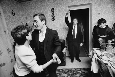 A couple dance at a New Year's party in a miner's apartment.