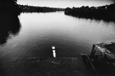 A man dives into an artificial lake next to a coal mine in the Donbas region.