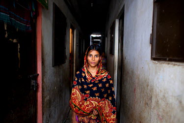 Tania in a corridor outside the windowless room where she lives with her children in Bishil.