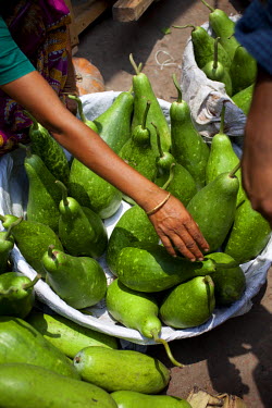 A woman selling a variety of gourd, a vegetable, at the Karwan Bazaar.