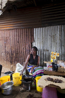 Maureen Aoko on the stall where she cooks and sells food outside her one-room house in Korogocho, Nairobi's poorest slum.