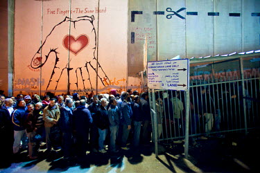 Palestinians wait at a checkpoint in Bethlehem at 5am in order to cross the border for work in Jerusalem.