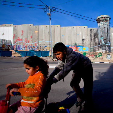 Two children play beside the Separation Wall.