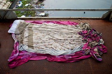 Sheets on the ground at the Sadarghat River Boat Terminal mark the space where Parvin Akhtar, a homeless woman, sleeps.