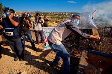 Photographers cover the weekly demonstration, held by Palestinian activists and their suppoters in Bilin (Bal'in), protesting at the construction of the Israeli Separation Wall, that caused the villag...