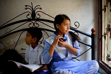 Suraiya (16), and one of her younger brothers at their family home in Naya Paltan.