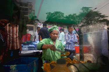Ariful Islam Zafar, known as Zafar, with the mobile food cart he uses to cook and sell snacks on the streets of Dhaka.