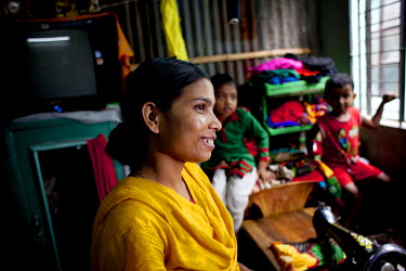 Moyna Begum at her home in Jhilpaar area, Mirpur, with the sewing machine she uses to run her tailoring business.  Moyna started a business making and selling clothes, having received training from Co...