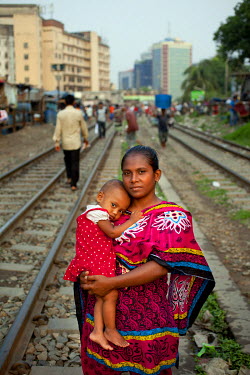 Fatema stands on the train tracks with her daughter Shimu, near where she used to live in Dhaka, Bangladesh.