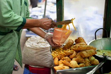 Ariful Islam Zafar serves food from a food cart he was given by Concern in Nari Moitree, Paltan, Dhaka.
