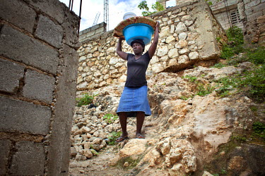 Suzzanne Vil carries a heavy load of eggs which she will sell from a pitch in the Carrefour district.
