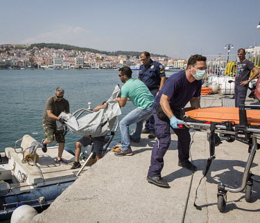 Greek coastguard officials and port police together with paramedics lift an unidentified body believed to be a migrant from a boat which had sunk near the Eastern coast of Lesbos. The boat, which had...