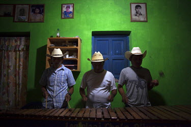 Men play marimba music as friends and family of the Chen family gather for a Mayan Ceremony at their home in Pacux the evening before the government was to begin paying reparations to hundreds of fami...