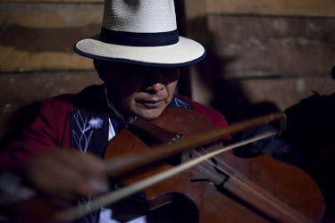 An Ixil Mayan massacre survivor and community organiser Nicolas Corio plays the violin as forensic anthropologists from the Center for Forensic Analysis and Applied Sciences (CAFCA) arrange, in coffin...