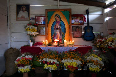 Candles light up an altar displaying images of former Q'eqchi' Mayan community leader, teacher and anti-mining activist Adolfo Ich Chaman. Ich Chaman was murdered on 27 September 2009, by Mynor Padill...