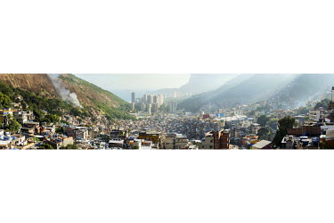 High rise condominiums in the wealthy neighbourhood of Sao Conrado, centre, and the sweeping landscape of Rocinha, the largest single favela in Rio de Janeiro. To the left smoke rises from a fire as r...