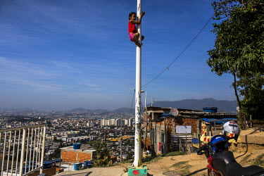 A child climbs a pole at the Palmeira cable car station in Complexo do Alemao in the North Zone.