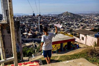A youth fly kites from the Palmeira cable car station in Complexo do Alemao in the North Zone.