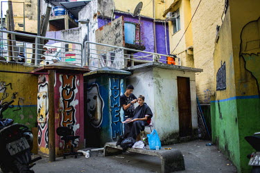 A young man gets his haircut at a makeshift outside barbershop in Rocinha, the largest single favela in Rio de Janeiro.