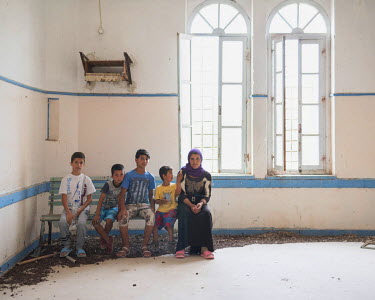 Refugees Diar, 13, Rebas, 9, Youssef, 14, Naswan, 5, and Kosh, 48, sitting in a room in the abandoned Lepida psychiatric hospital in whose grounds the Leros Hot spot (an EU-run migrant's reception cen...