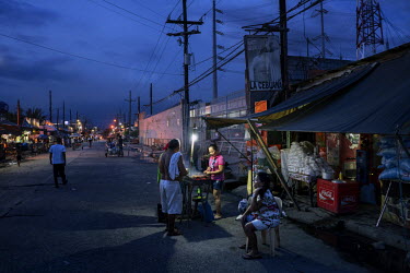 Dock workers and fishermen buy food from a street vendor inside the Navotas Fish Port complex, the largest fish port in the Philippines. The markets at Navotas Fish Port trade in fish and other seafoo...