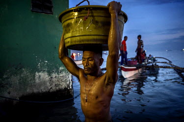 Dock workers unload fresh water fish at one of the markets in the Navotas Fish Port - the largest fish port in the Philippines - in Manila, The Philippines on July 1st, 2016. The markets at Navotas Fi...