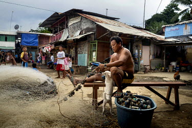 A fisherman mends his nets in the fishing community of Liberty. Overfishing in the South China Sea has a trickle down impact on the smaller fishing communities like this one that fish in national and...