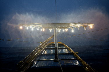 The lights used to attract fish towards the boat shine during a storm on the 'Melissa', a 15.53 gross ton basnig fishing boat, as it heads out to fishing grounds in national waters close to the South...