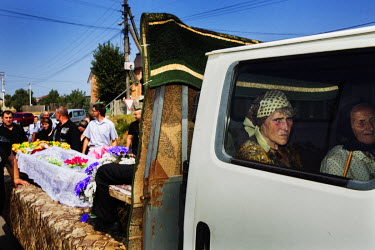 Relatives and their deceased grandmother make a procession to the cemetery for her burial.