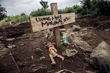 Dolls lie on of the grave of an Ebola victim in the King Tom cemetery.